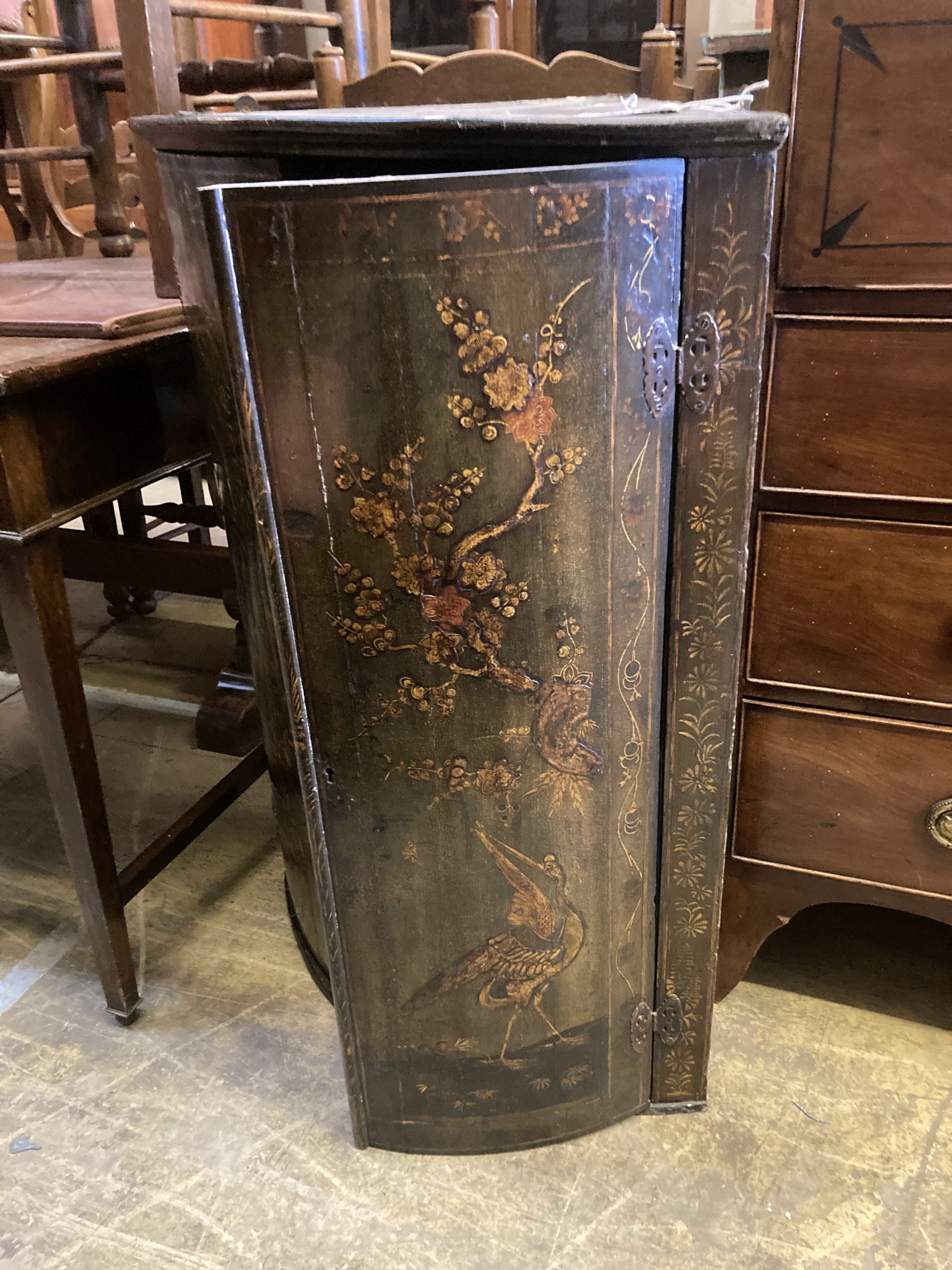 An 18th century chinoiserie lacquered bow front hanging corner cupboard, on later oak stand, width 66cm, depth 45cm, height 95cm